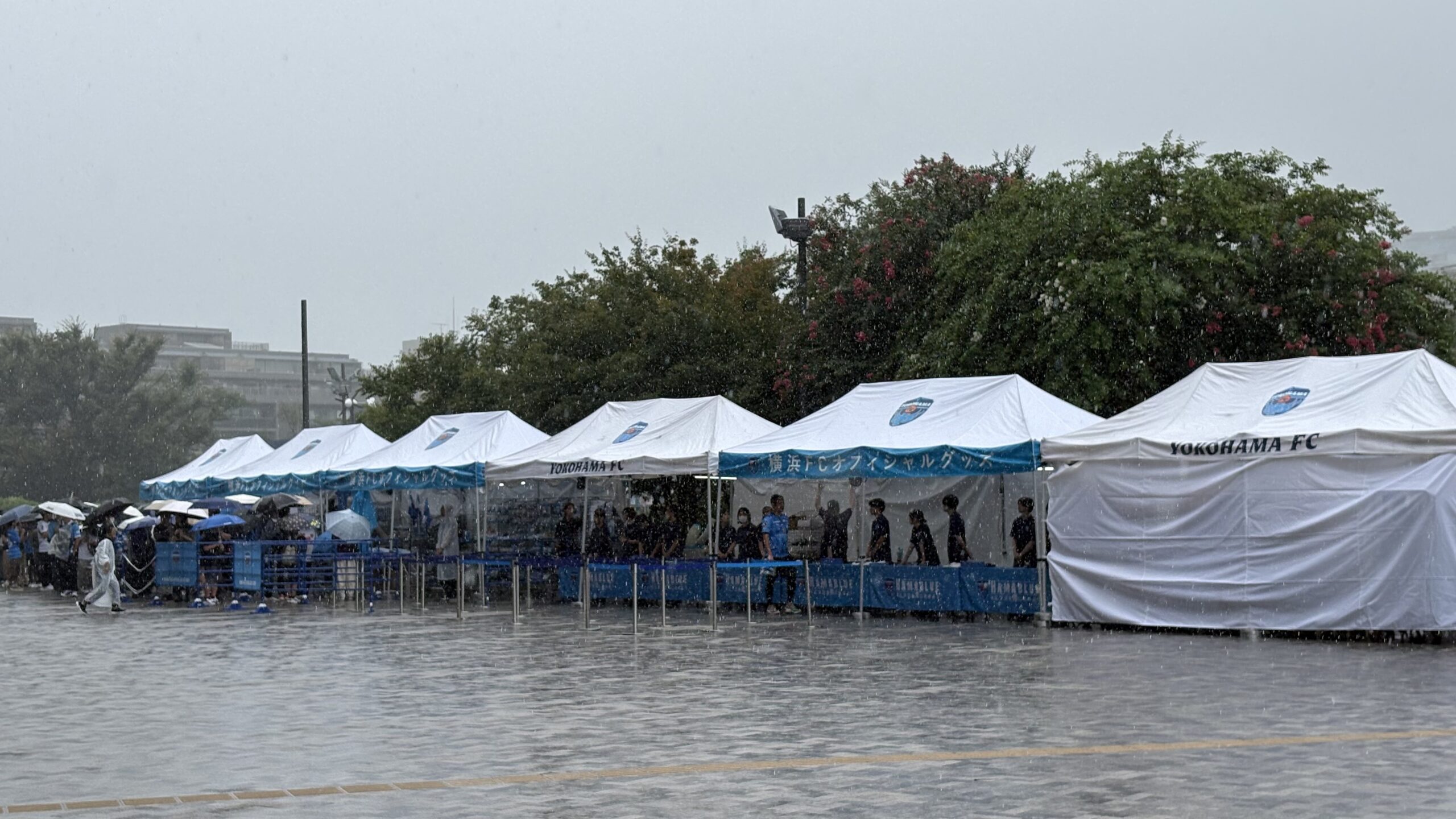 雨の中、横浜FCオフィシャルグッズストアに並ぶ来場者の列