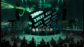 A group of people on stage with a large screen with numbers

AI-generated content may be incorrect.