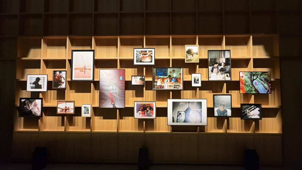 木の棚に飾られた家族やいのちをテーマにした写真の数々