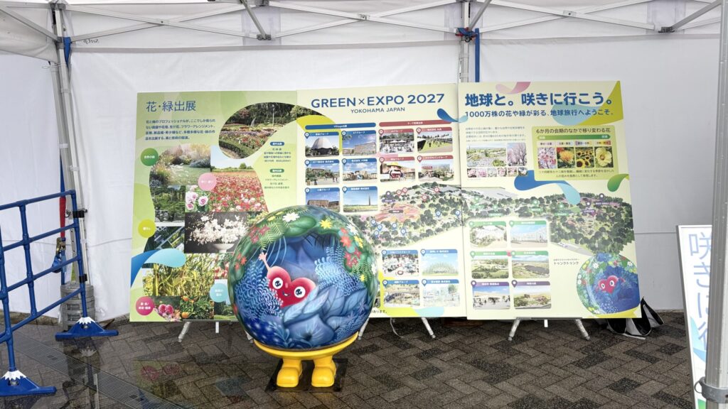 花・緑出展と会場計画を紹介するパネル3面と、その前に置かれたトゥンクトゥンクの地球オブジェ
