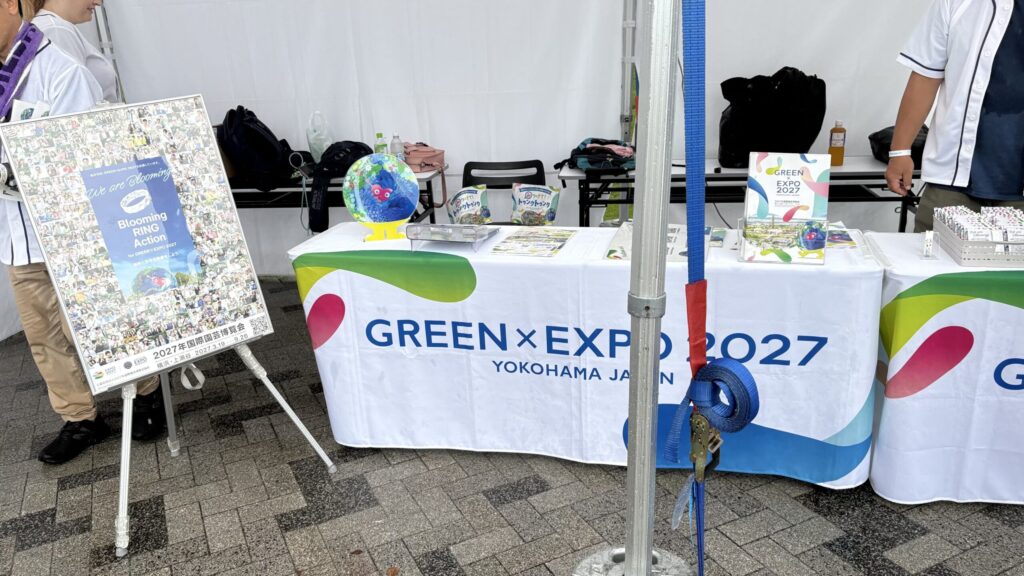 GREEN×EXPO 2027のロゴが入ったテーブルクロスとパンフレットが並ぶPRブース