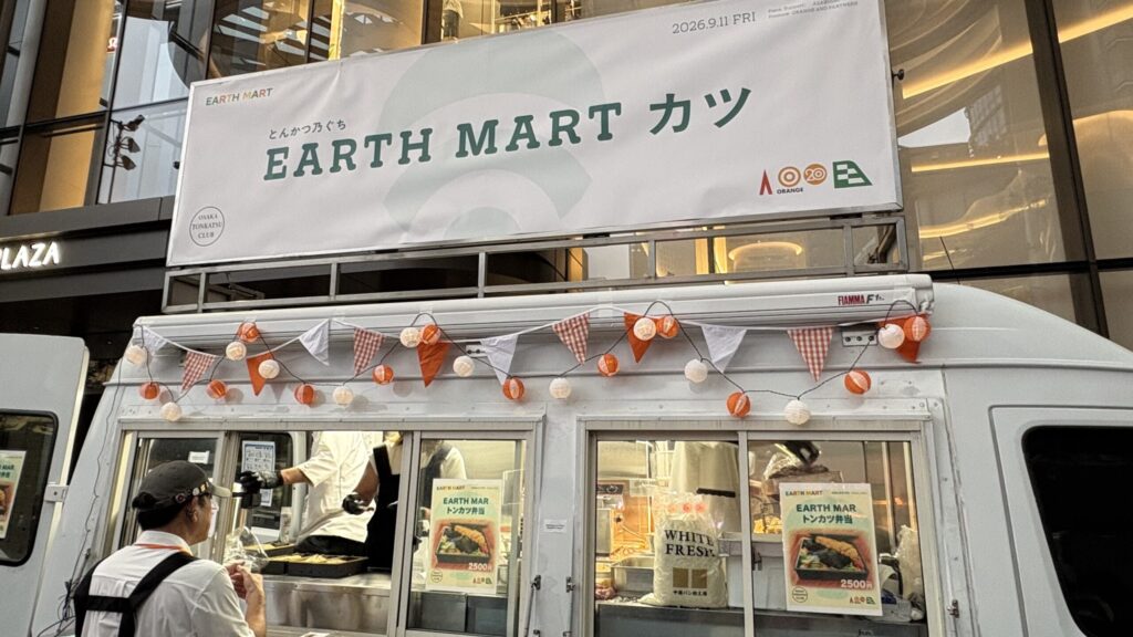 とんかつ乃ぐちのキッチンカーと「EARTH MART カツ」の看板