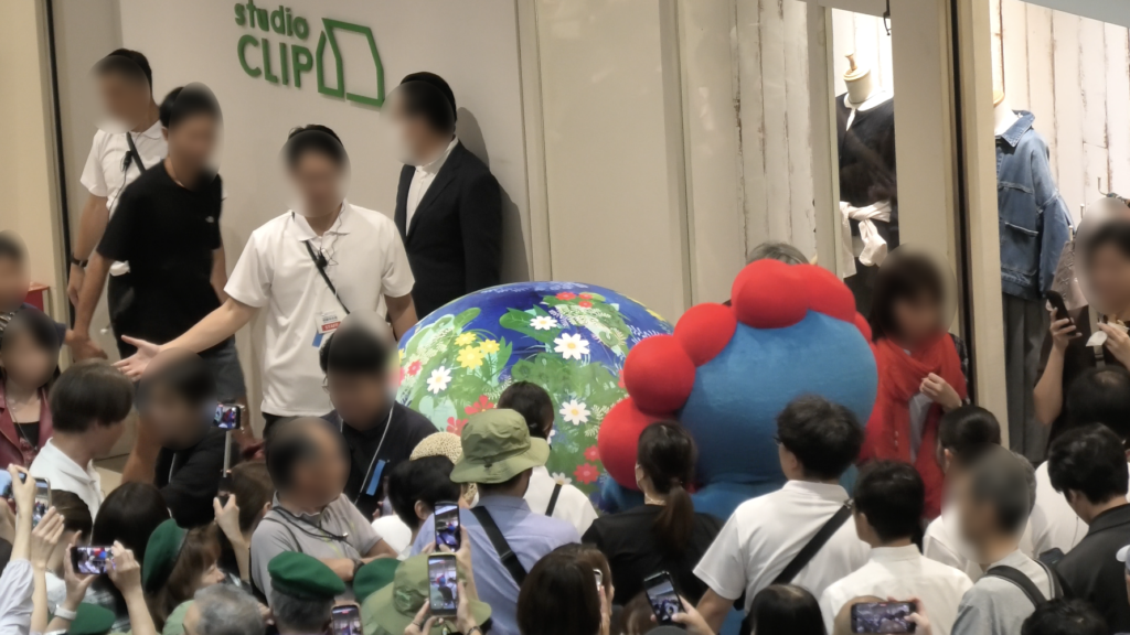 人垣のあいだを通って登場するトゥンクトゥンクとミャクミャク