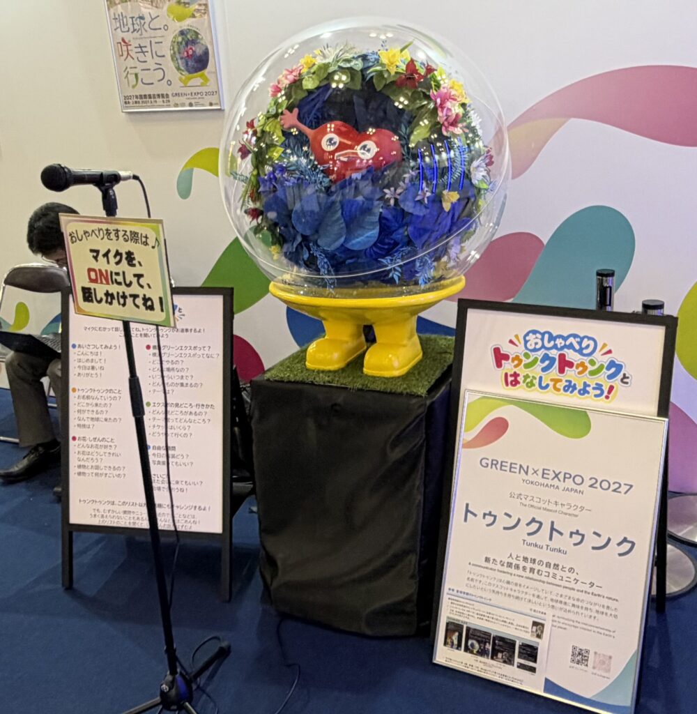 ブースK-03に置かれた、話しかけられるトゥンクトゥンクのモニュメントとマイク
