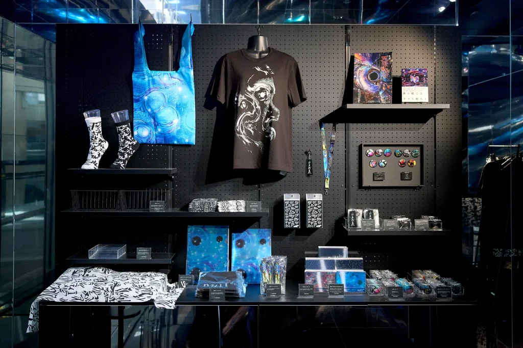 null² shopの棚。Tシャツ、トートバッグ、靴下、缶バッジ、書籍などが並ぶ