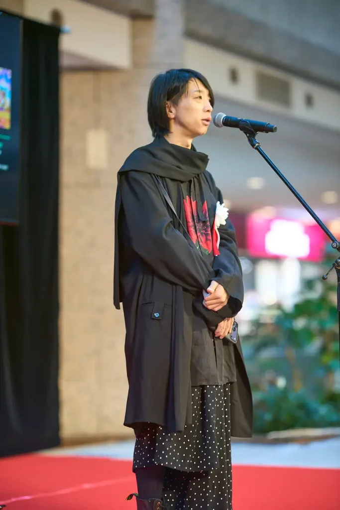 開業記念式典のステージでマイクの前に立つ落合陽一さん