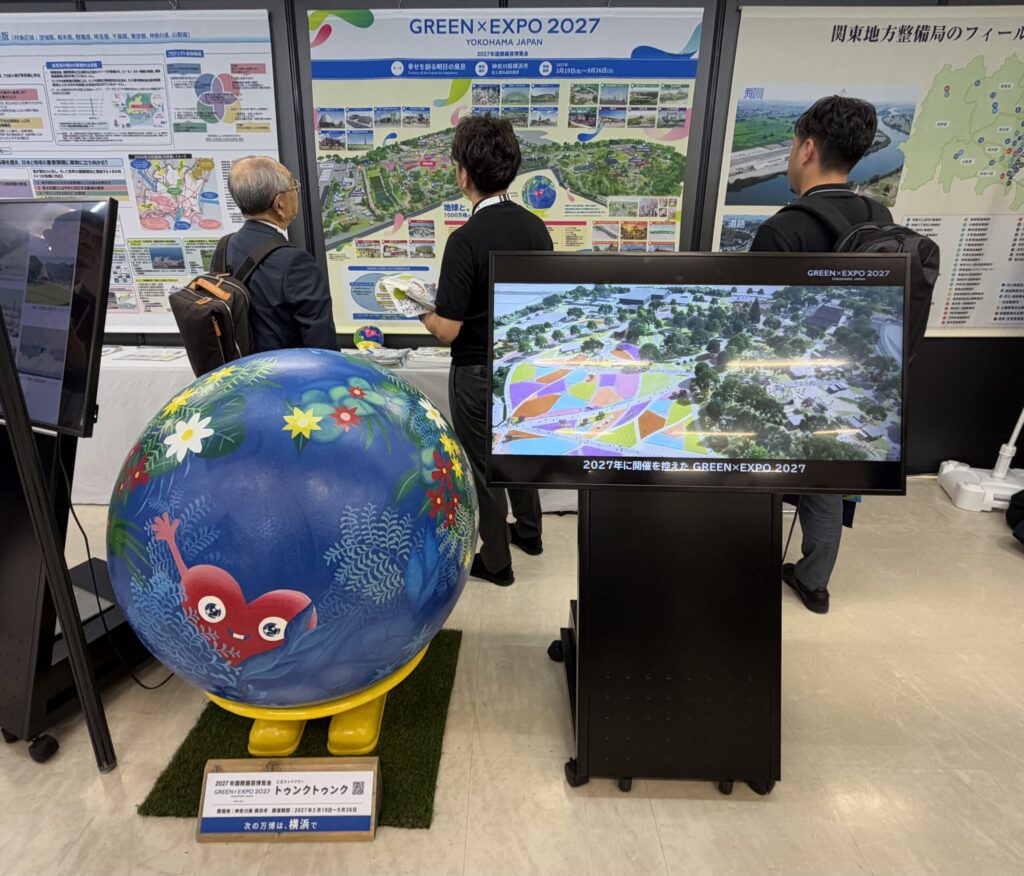 国土交通省のブースに置かれたトゥンクトゥンクのモニュメントと、GREEN×EXPO 2027の会場の映像