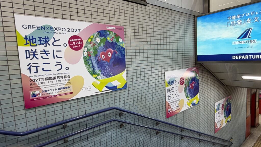 羽田空港第1・第2ターミナル駅の階段に並ぶGREEN×EXPO 2027のポスター