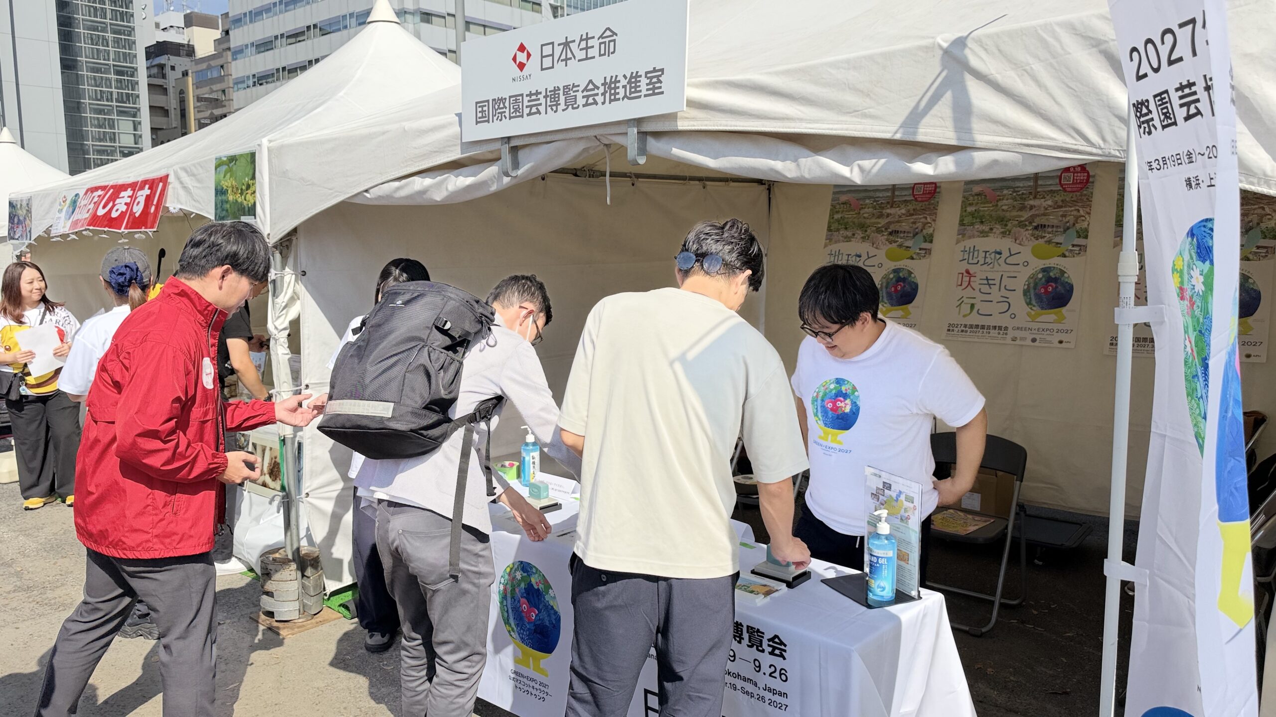 日本生命 国際園芸博覧会推進室のブースでスタンプを押す来場者