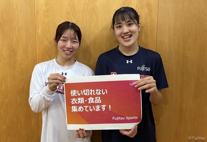 「使い切れない衣類・食品集めています!」のボードを持つ富士通レッドウェーブの選手