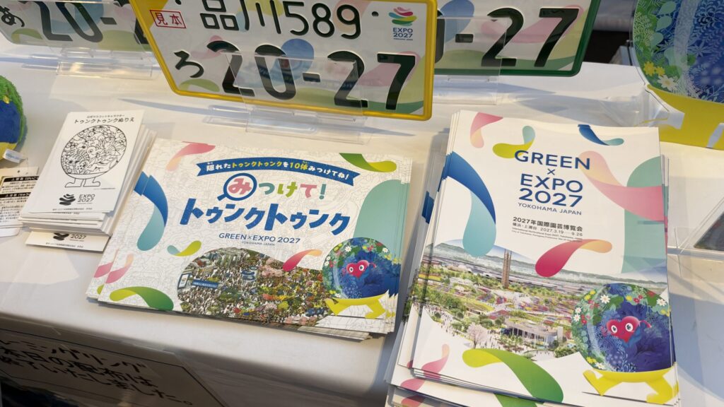 みつけて!トゥンクトゥンクのパンフレットとGREEN×EXPO 2027の図柄入りナンバープレートの見本