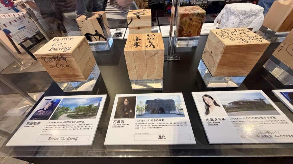 大屋根リングの端材にプロデューサーのサインが刻まれた展示