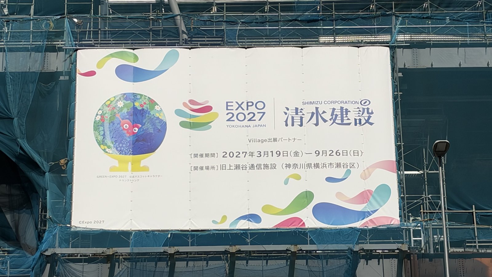 建設現場の足場に掲げられたEXPO 2027と清水建設のバナー
