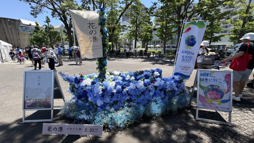 青い花で飾られた「花の港」の装飾と、GREEN×EXPO 2027ののぼり