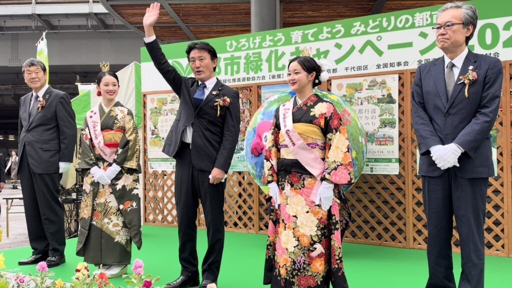 セレモニーで手を振る井林辰憲 国土交通大臣と、さくらプリンセス、さくらの女王