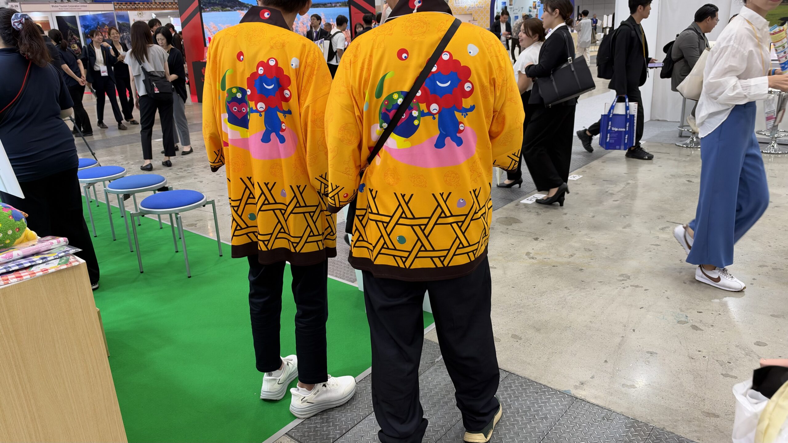 トゥンクトゥンクとミャクミャクが描かれた黄色い法被の背中