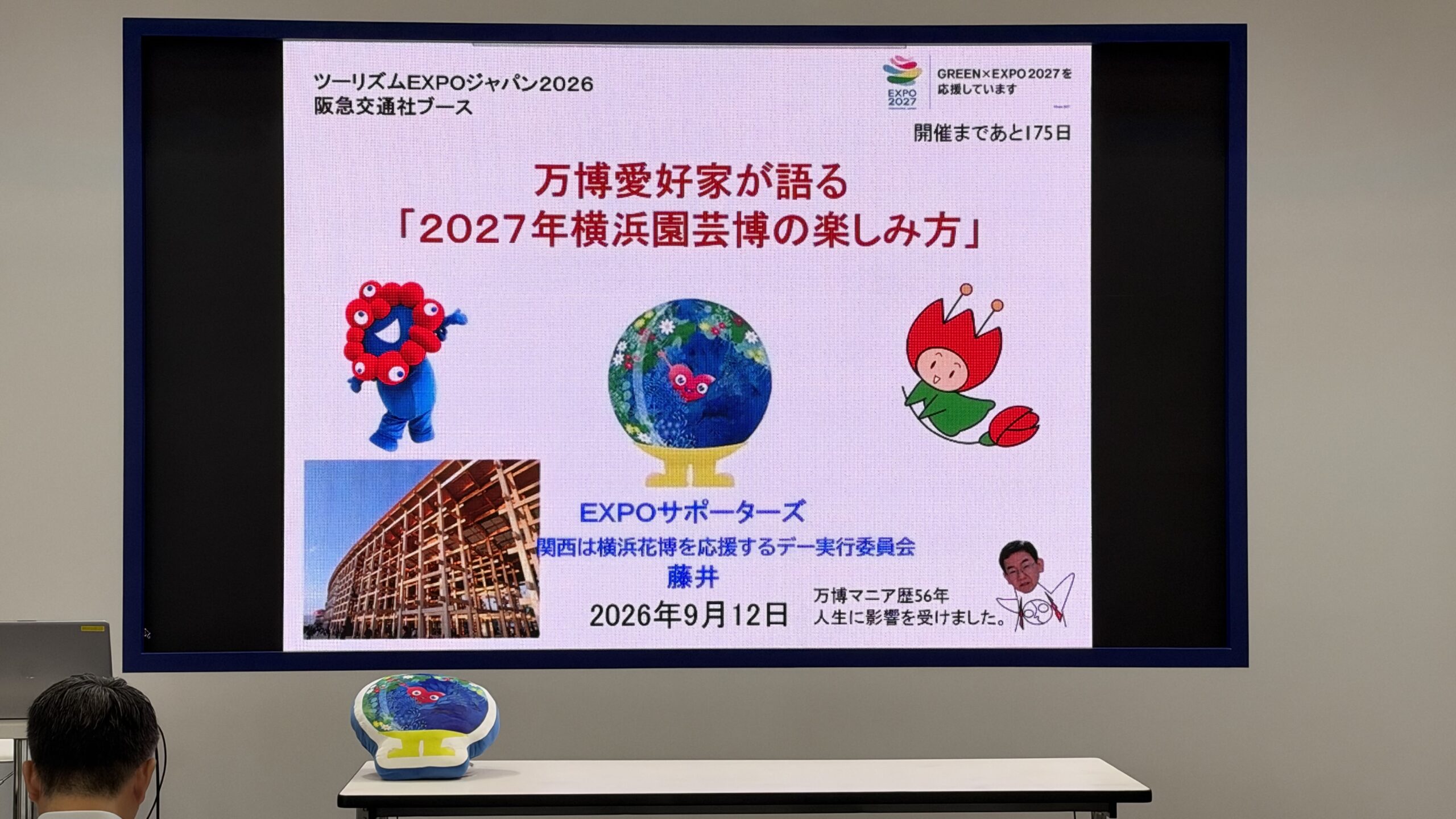 阪急交通社ブースのスクリーンに映る「万博愛好家が語る『2027年横浜園芸博の楽しみ方』」のスライド