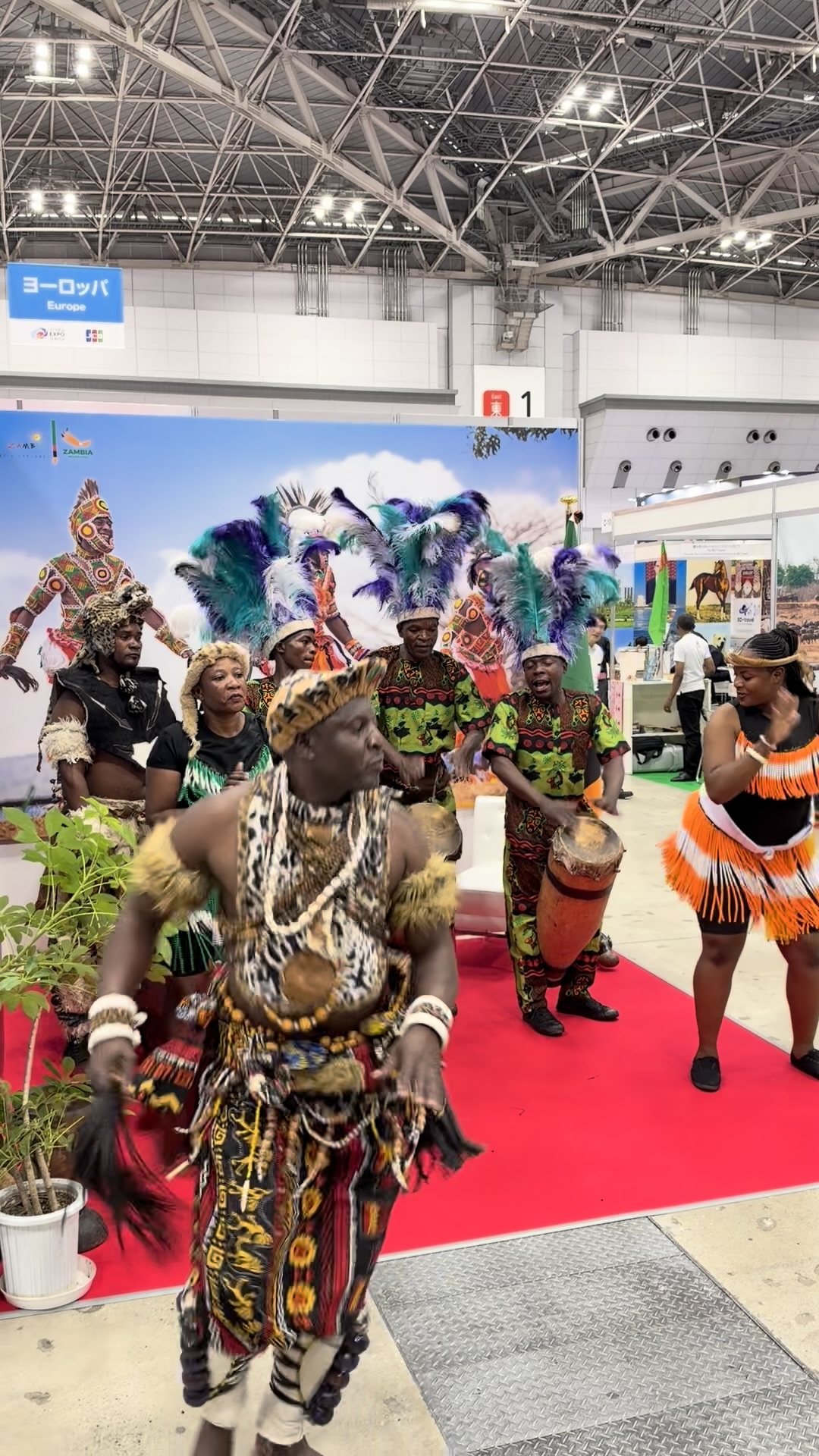 羽根飾りや民族衣装で太鼓に合わせて踊るパフォーマー