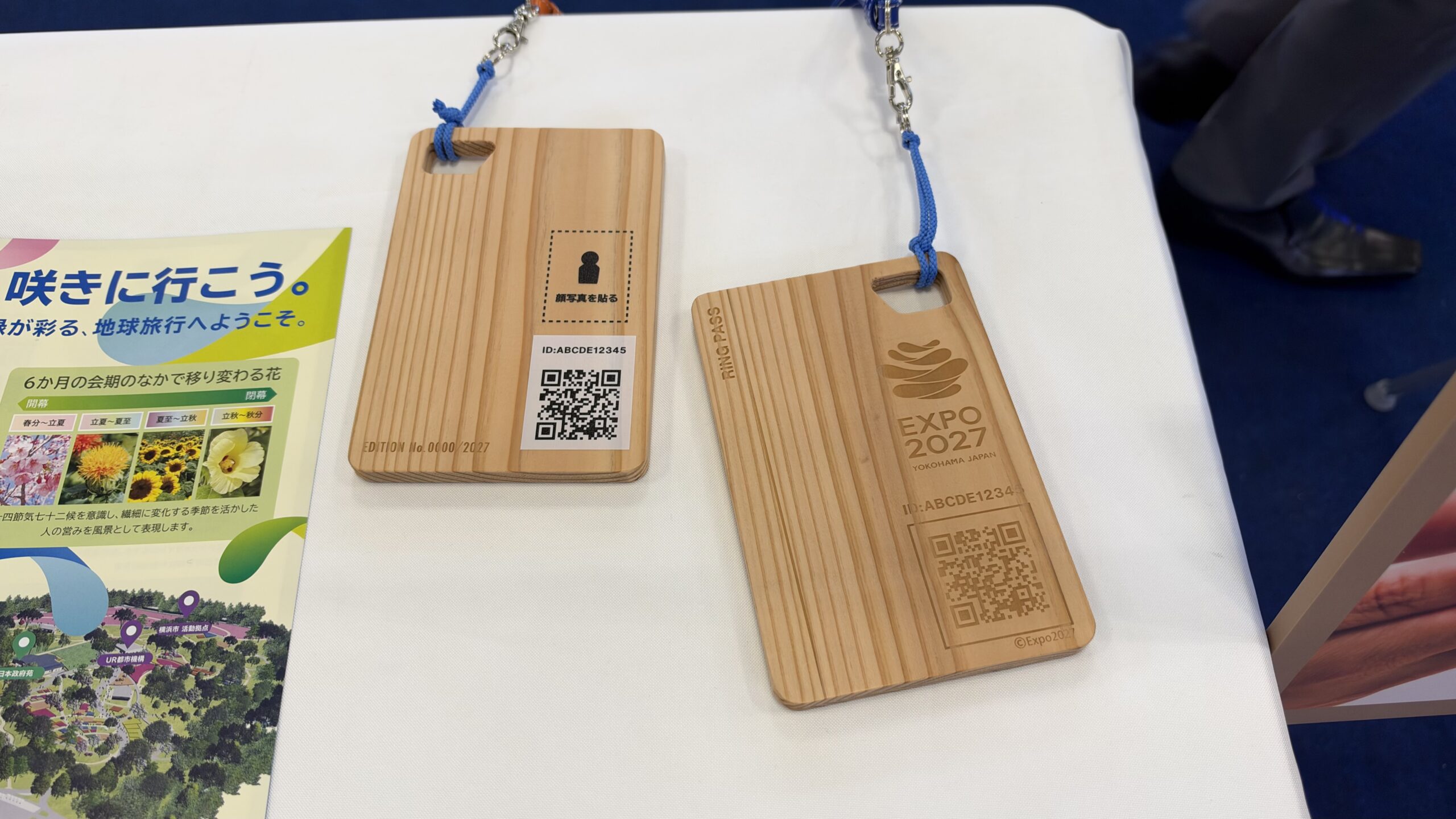 ブースのテーブルに置かれた木製の入場チケットRING PASSの見本2枚とパンフレット